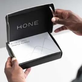 A man holding a box that contains Hone's at-home assessment